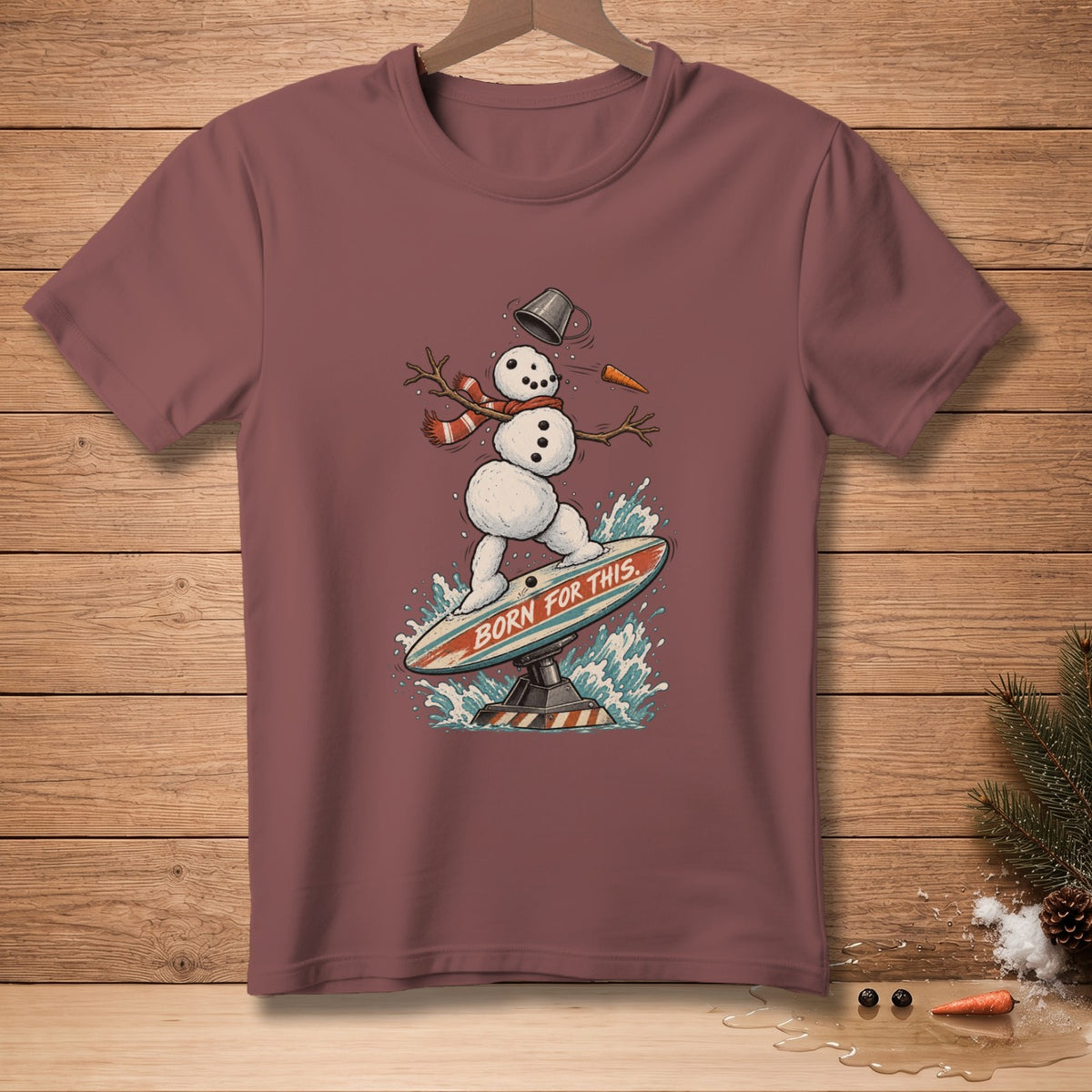 Snowman surfing with text "BORN FOR THIS" on a surfboard.
