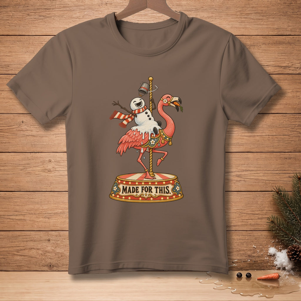 Brown t-shirt with a flamingo riding a carousel pole, holding a snowman and wearing a scarf.