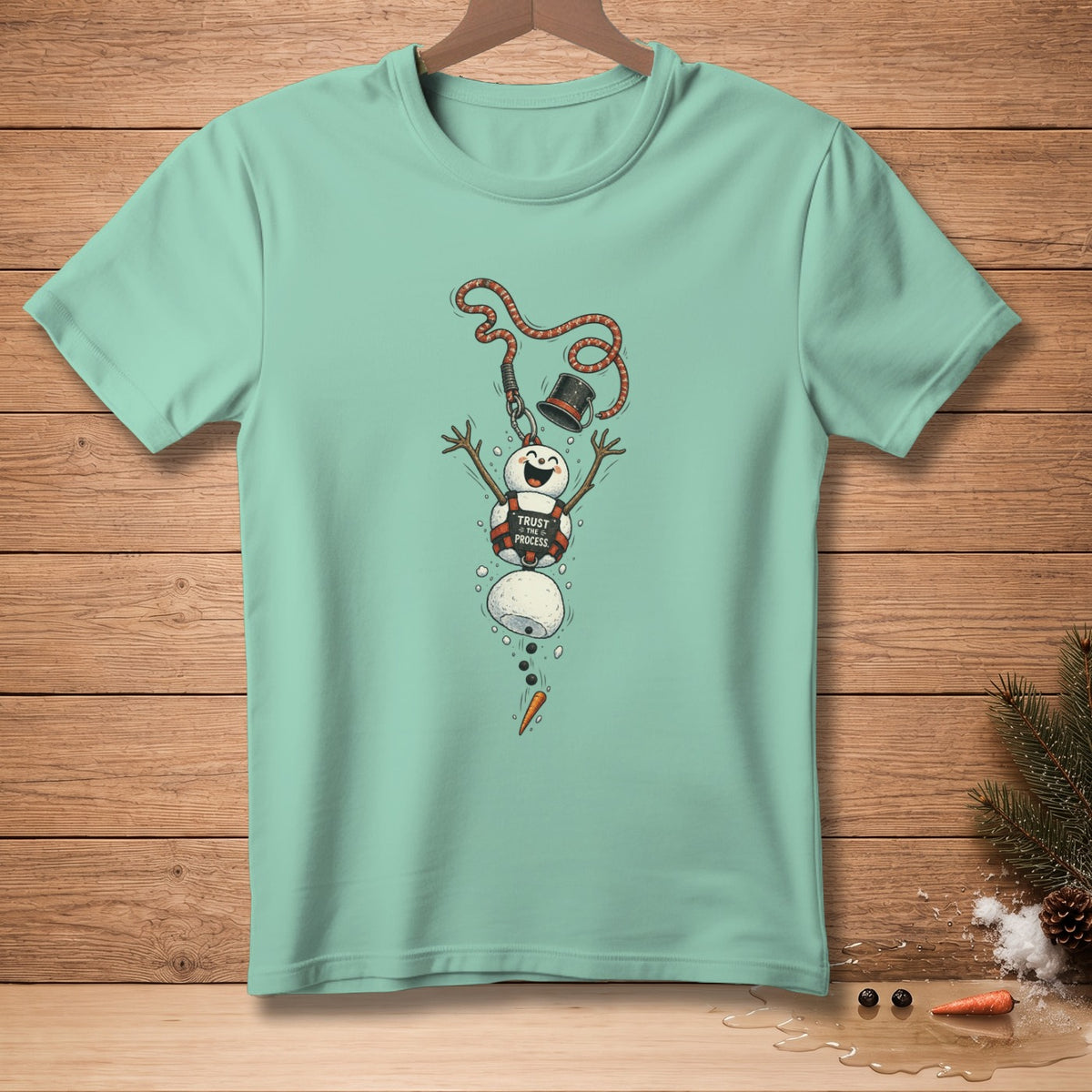 Mint green t-shirt with a melting snowman graphic that says "Trust the Process".
