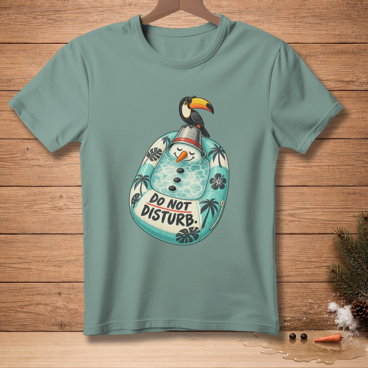 T-shirt with a cartoon snowman in an inflatable ring with a toucan on its hat.