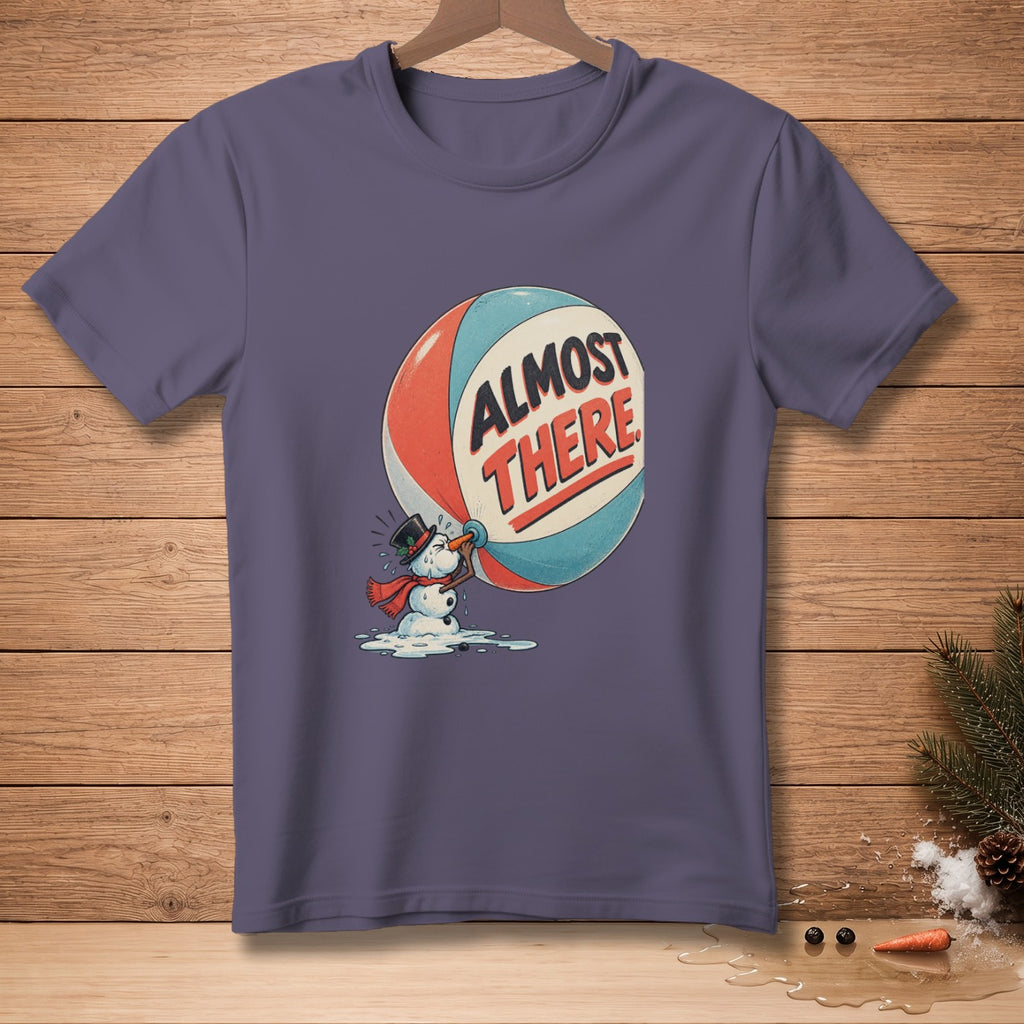 T-shirt graphic of melting snowman holding sphere with text "ALMOST THERE".