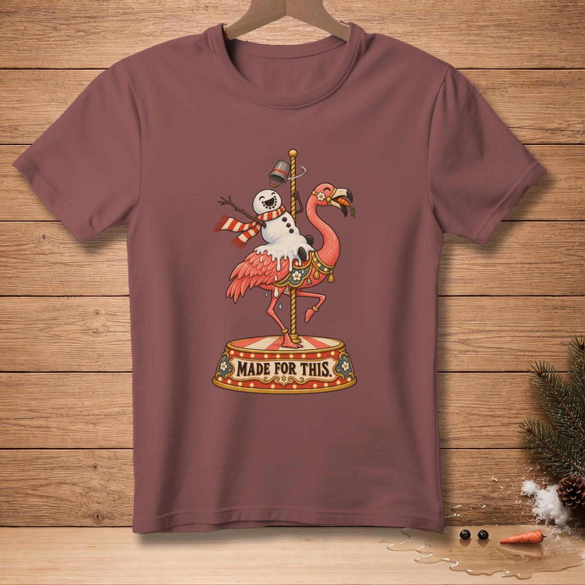 T-shirt with a humorous Christmas graphic of a flamingo with a snowman riding it.