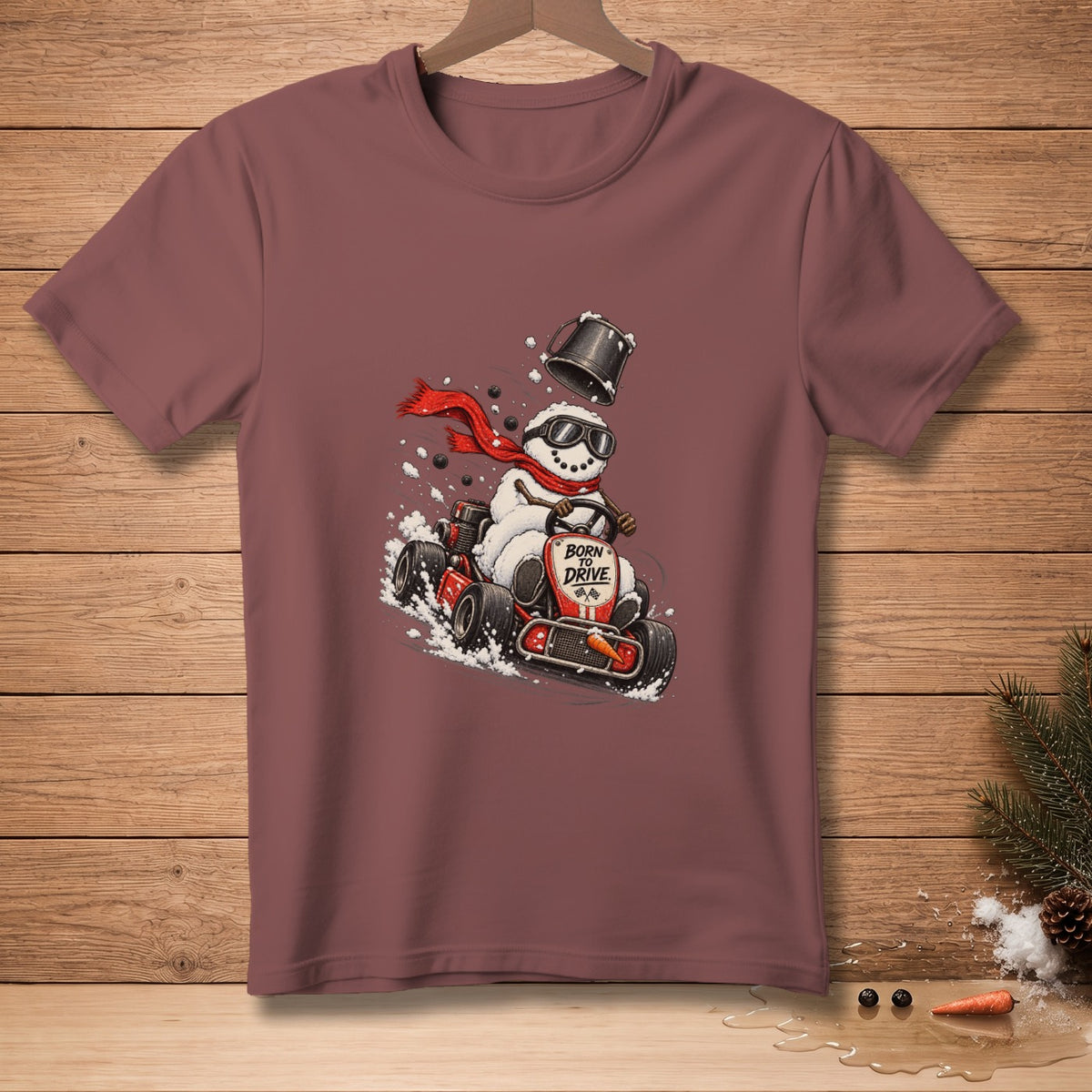 Snowman in go-kart with red scarf and bucket, text reads "BORN TO DRIVE".