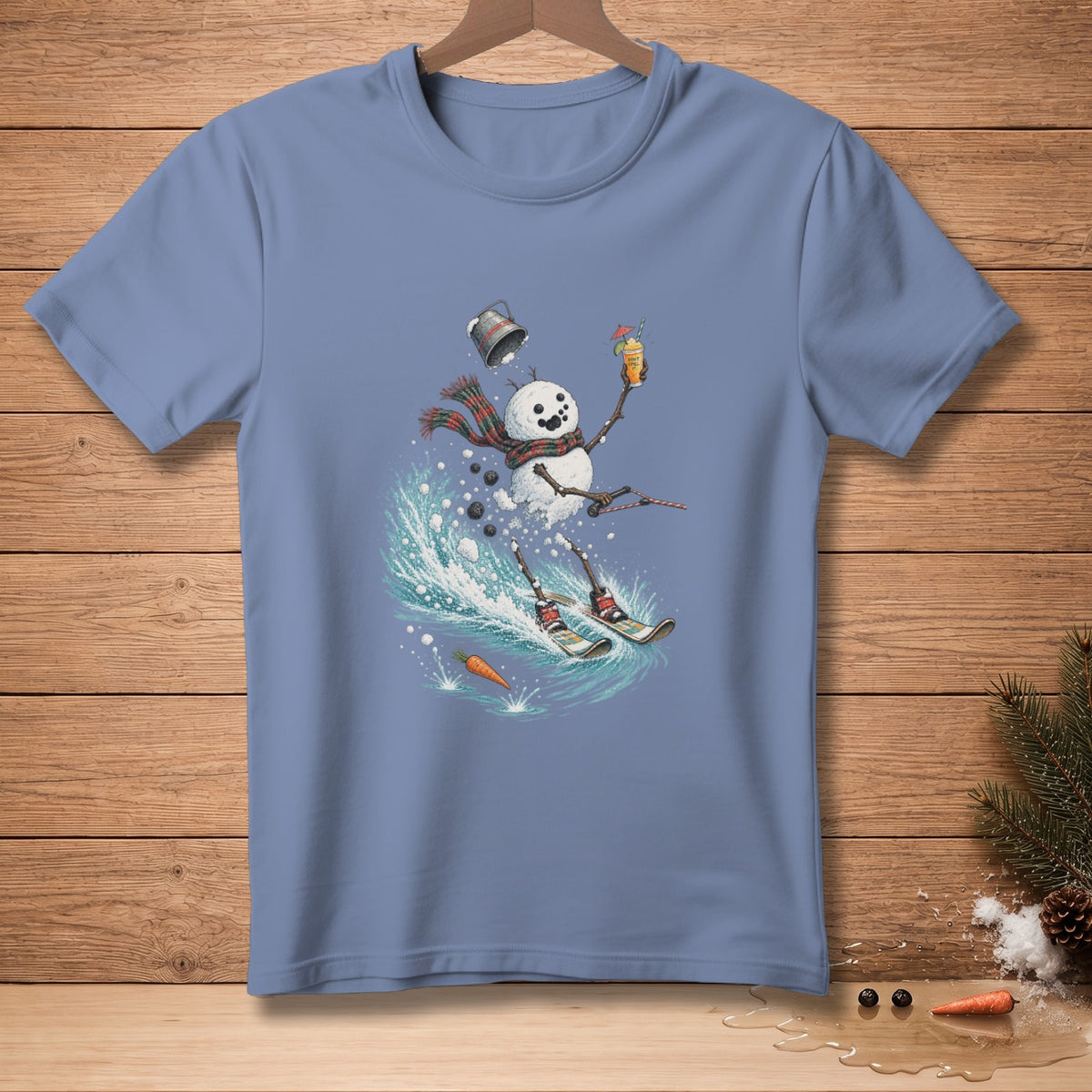 Blue t-shirt featuring a snowman skiing with a drink, scarf, and fallen bucket.