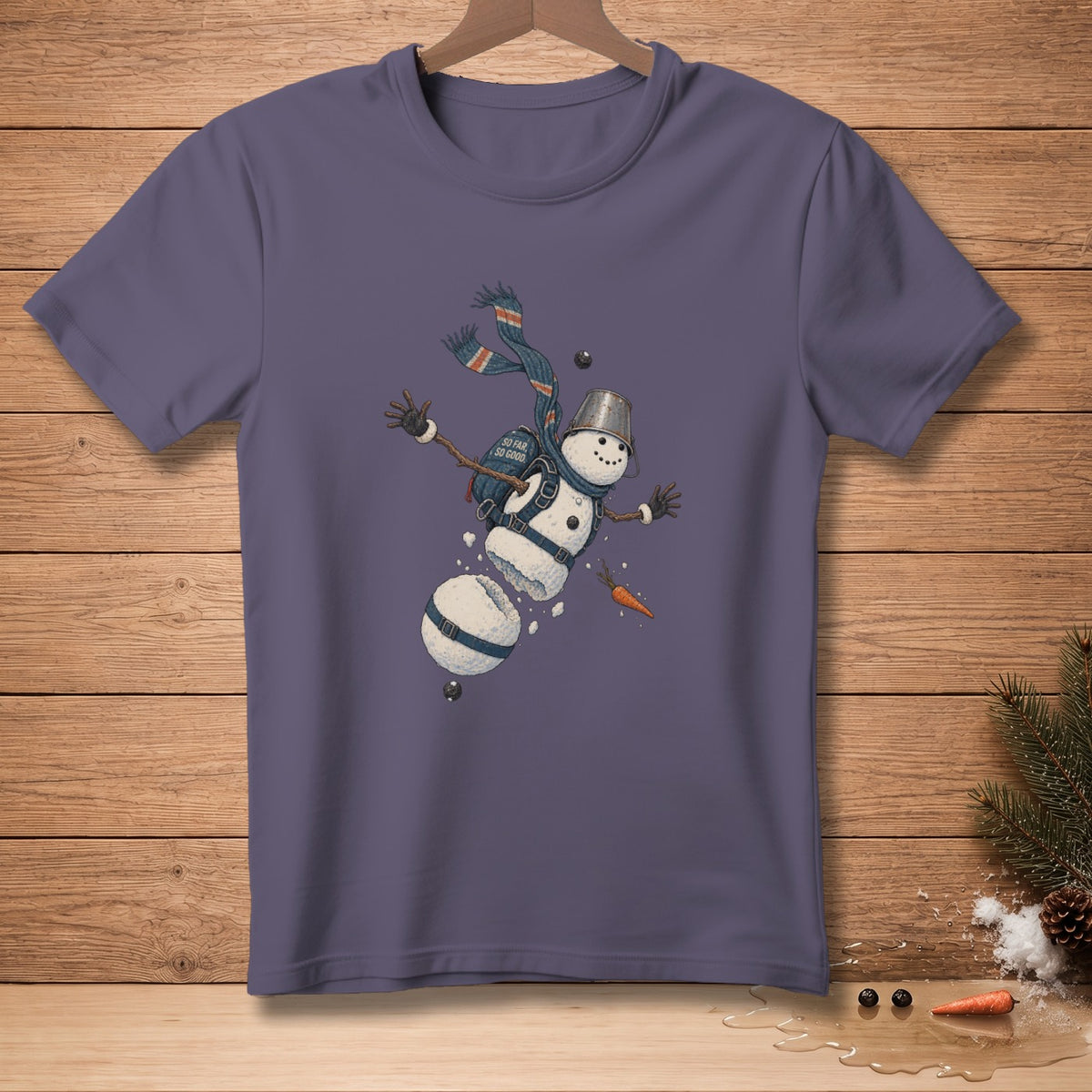 T-shirt with a drawing of a falling snowman wearing a scarf and bucket hat.