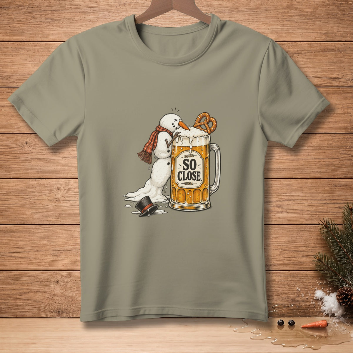 Melting snowman with scarf reaching for pretzel on beer mug with "SO CLOSE" text.