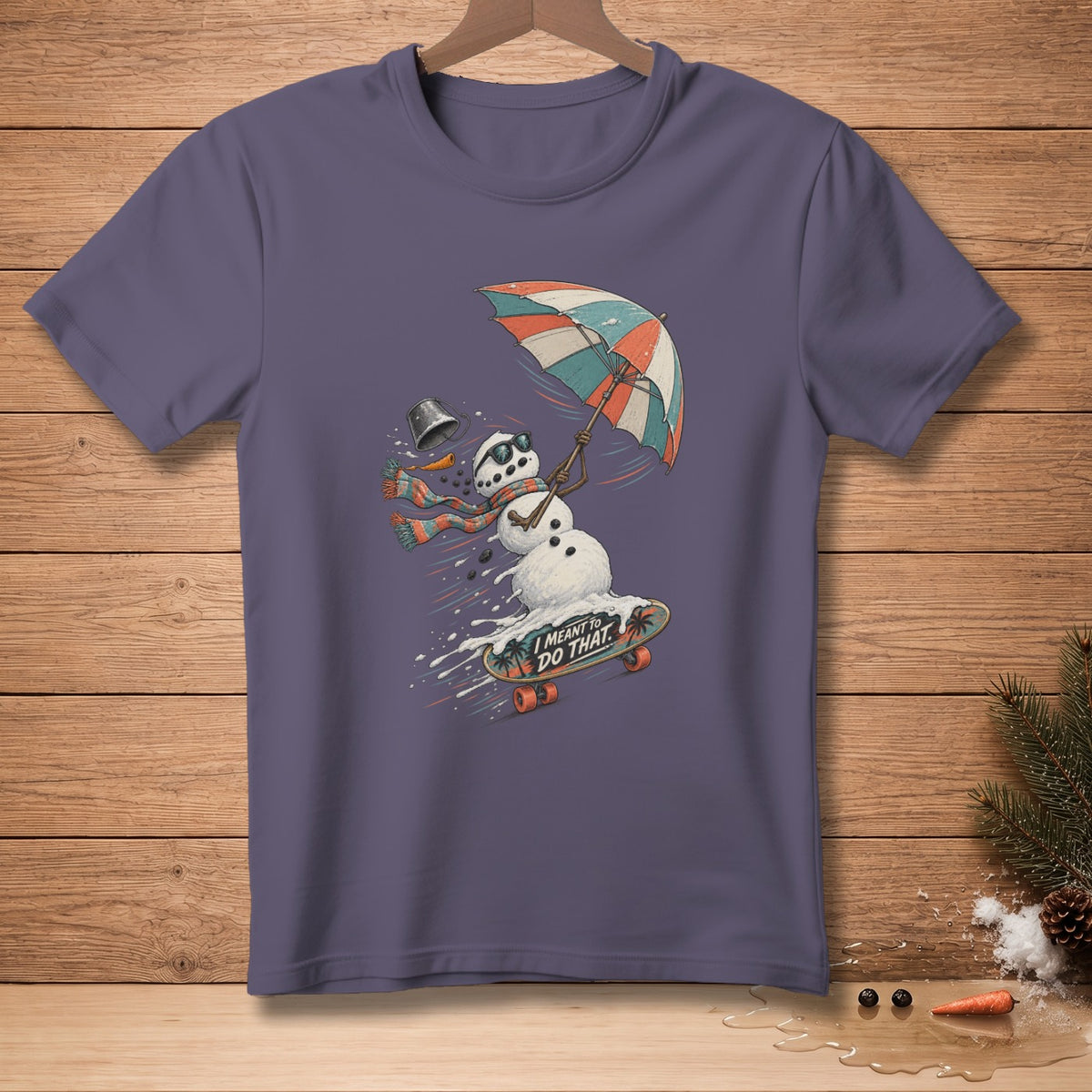 Snowman skateboarding with umbrella, holding bucket, text "I meant to do that."