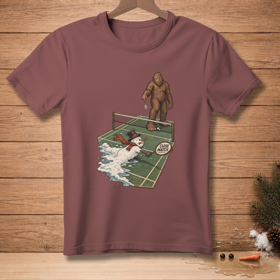 Bigfoot plays tennis against a melting snowman with a "Close Match" sign.