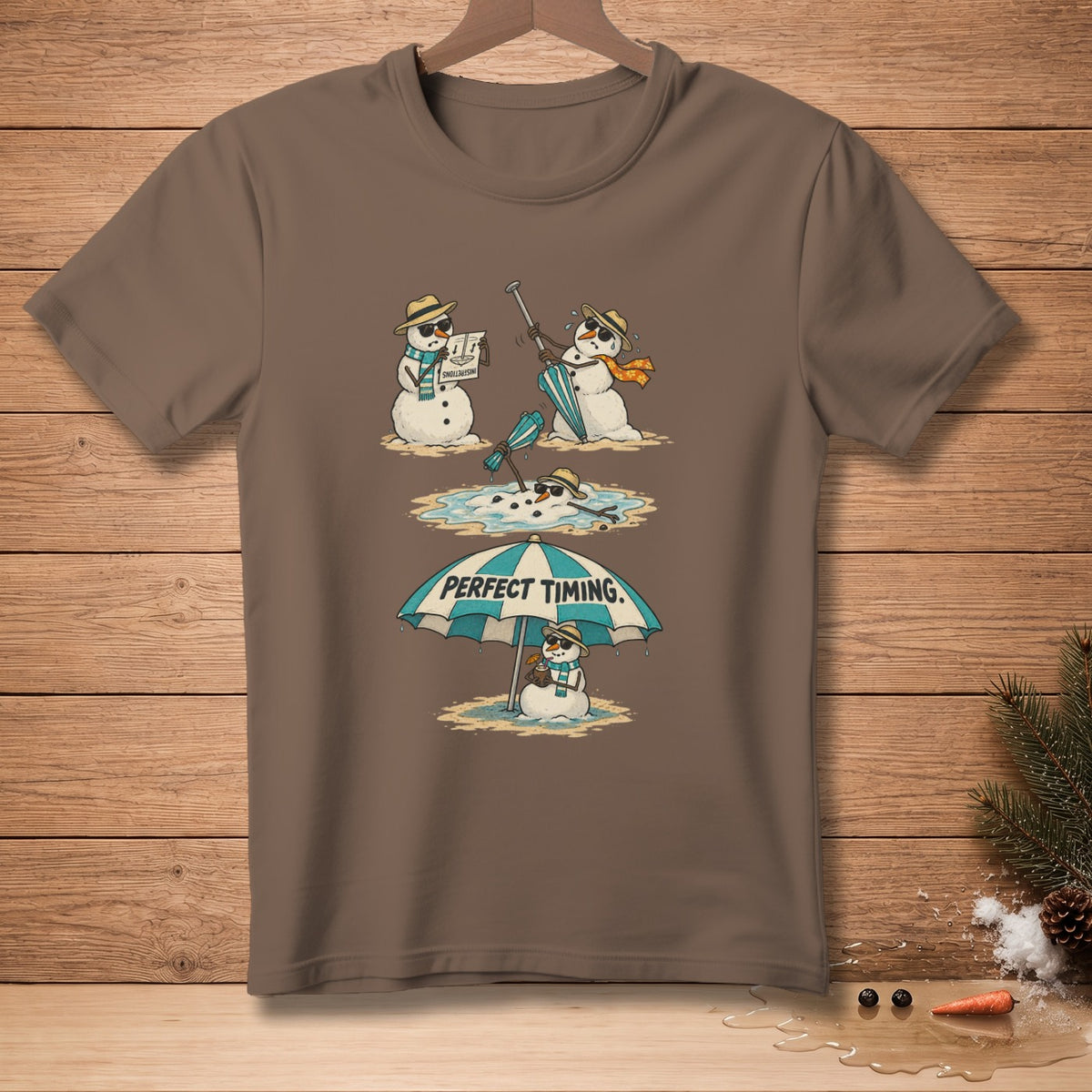 Brown t-shirt with a comic strip of melting snowmen under a beach umbrella with text "PERFECT TIMING."