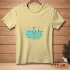Light yellow t-shirt with cartoon snowmen sinking in water with carrots.