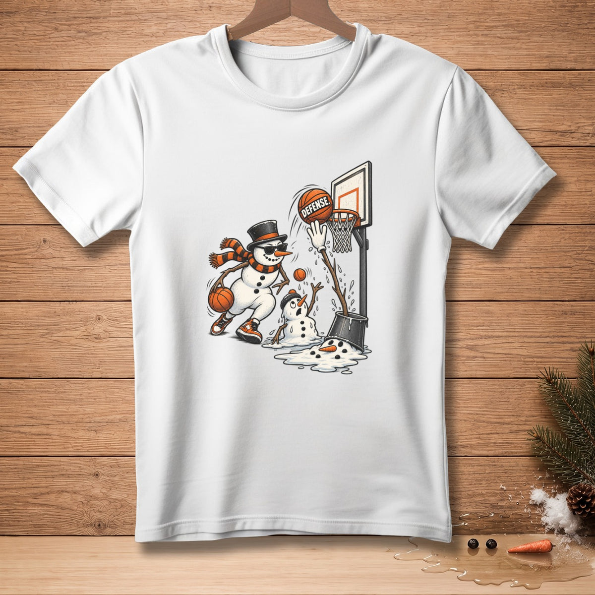 White t-shirt with snowmen playing basketball, one is shooting while another melts.