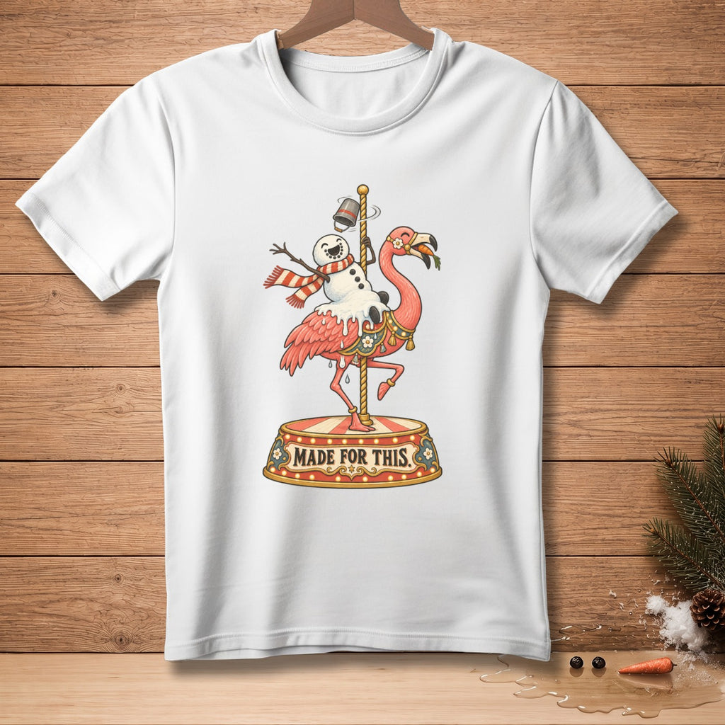 White t-shirt with a snowman riding a flamingo on a carousel, text reads "MADE FOR THIS".