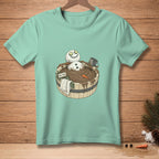 Snowman in a mud bath with cucumber eyes, bucket, carrot, and "DETOX" sign.