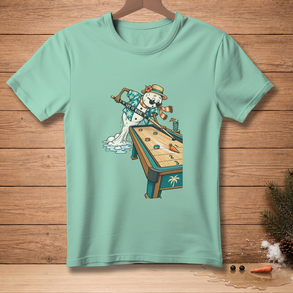 Snowman playing shuffleboard on a teal t-shirt with "LET IT RIDE" text.