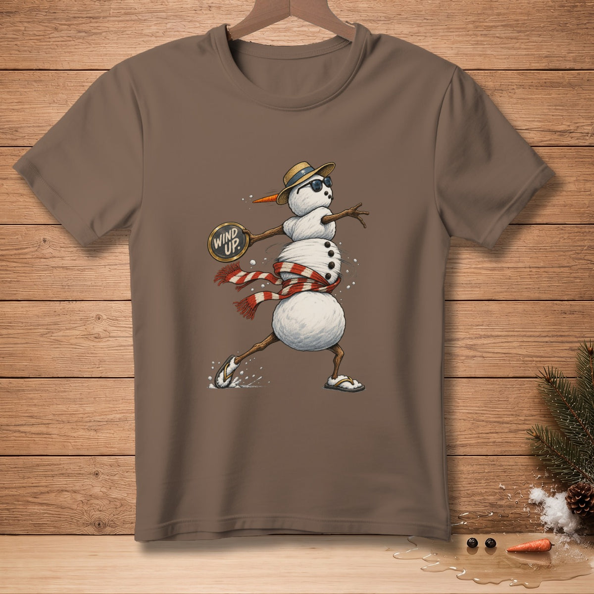 Brown t-shirt with cartoon snowman wearing a hat, sunglasses, and scarf.