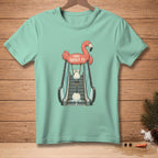 Mint t-shirt with graphic of a flamingo holding a melting snowman on an escalator.