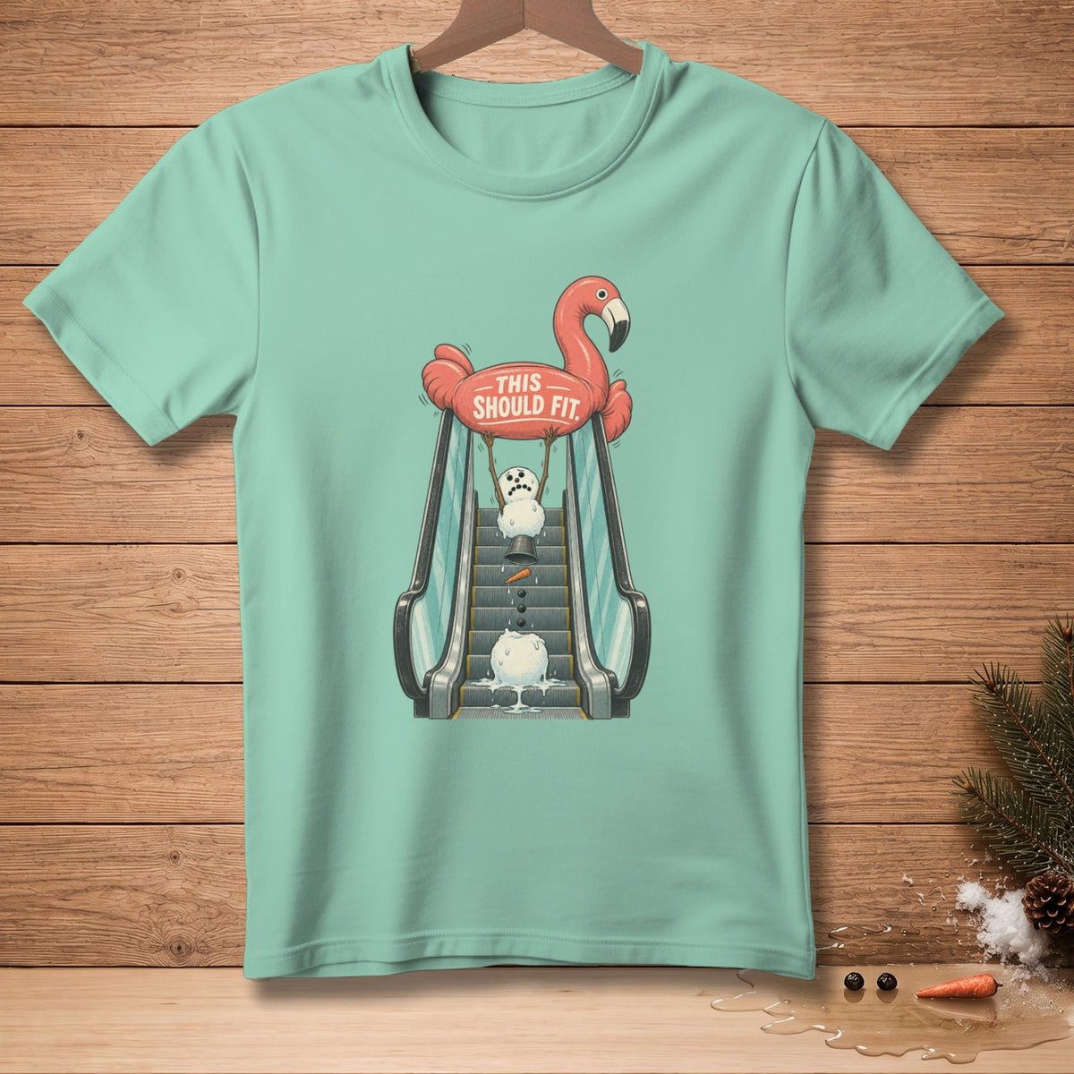 Mint t-shirt with graphic of a flamingo holding a melting snowman on an escalator.