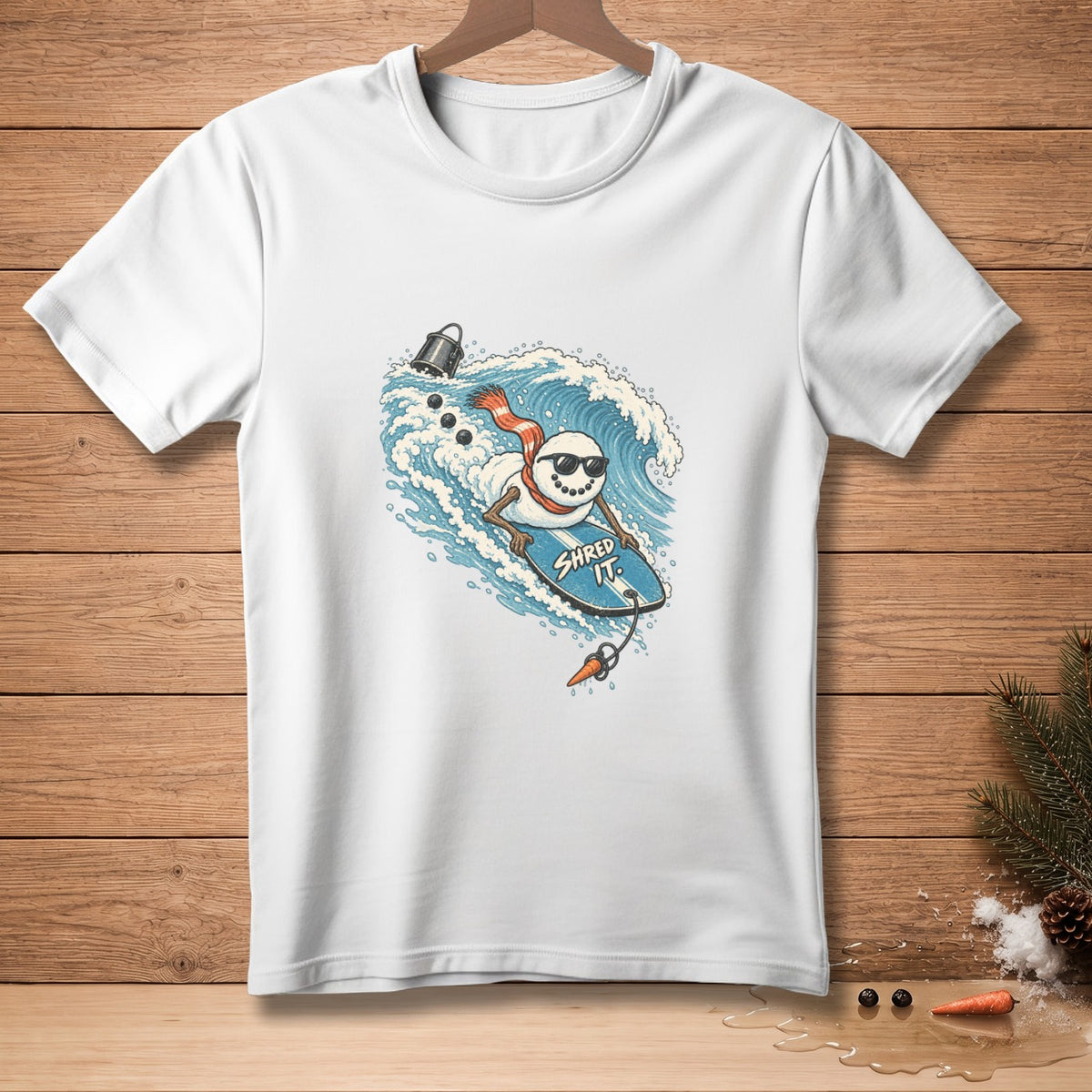 Snowman with sunglasses and scarf surfs a wave on a blue board with "SHRED IT."