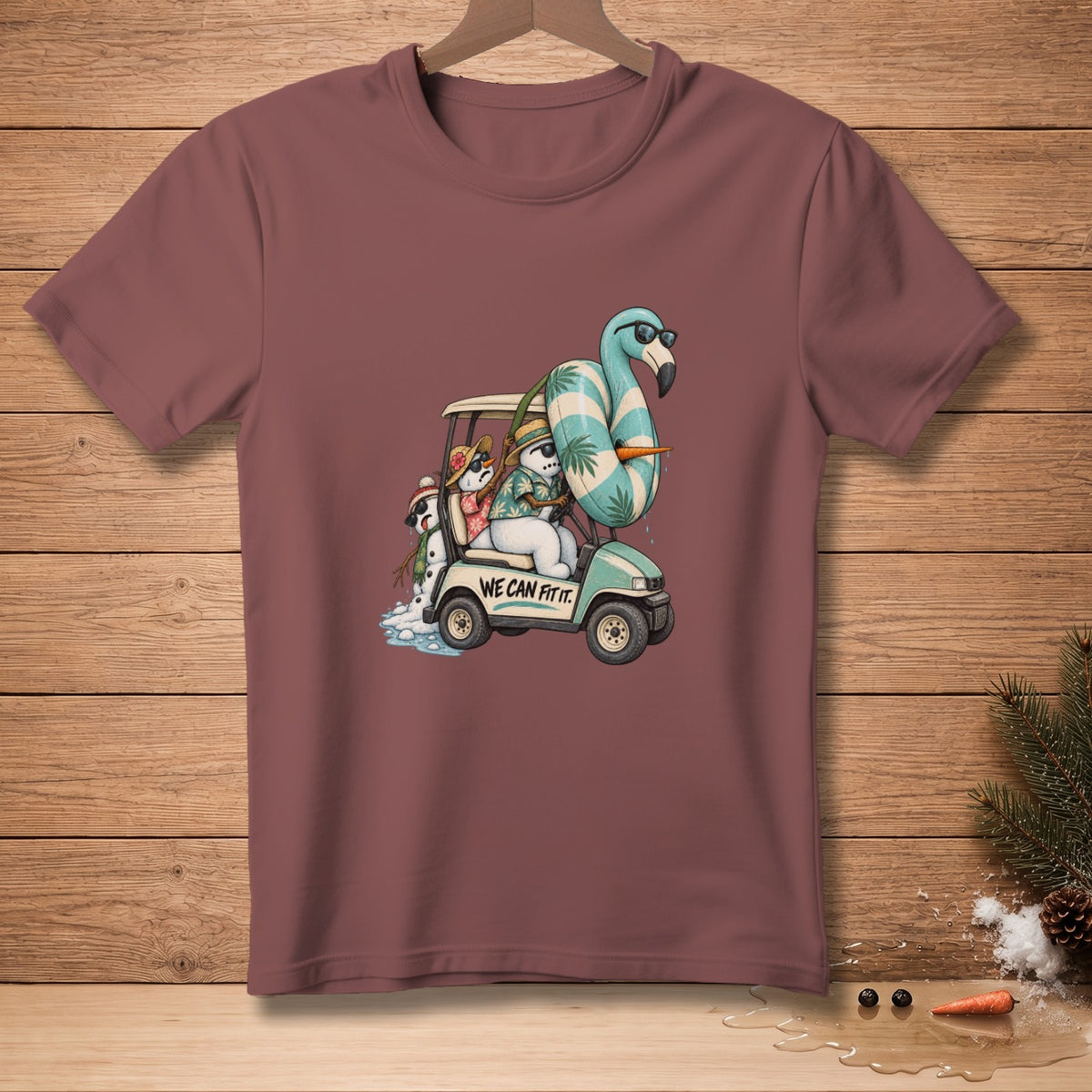 Snowmen in a golf cart with a flamingo and a beach ball, reads "WE CAN FIT IT".