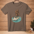 Bigfoot paddleboarding on a surfboard with a melting snowman.