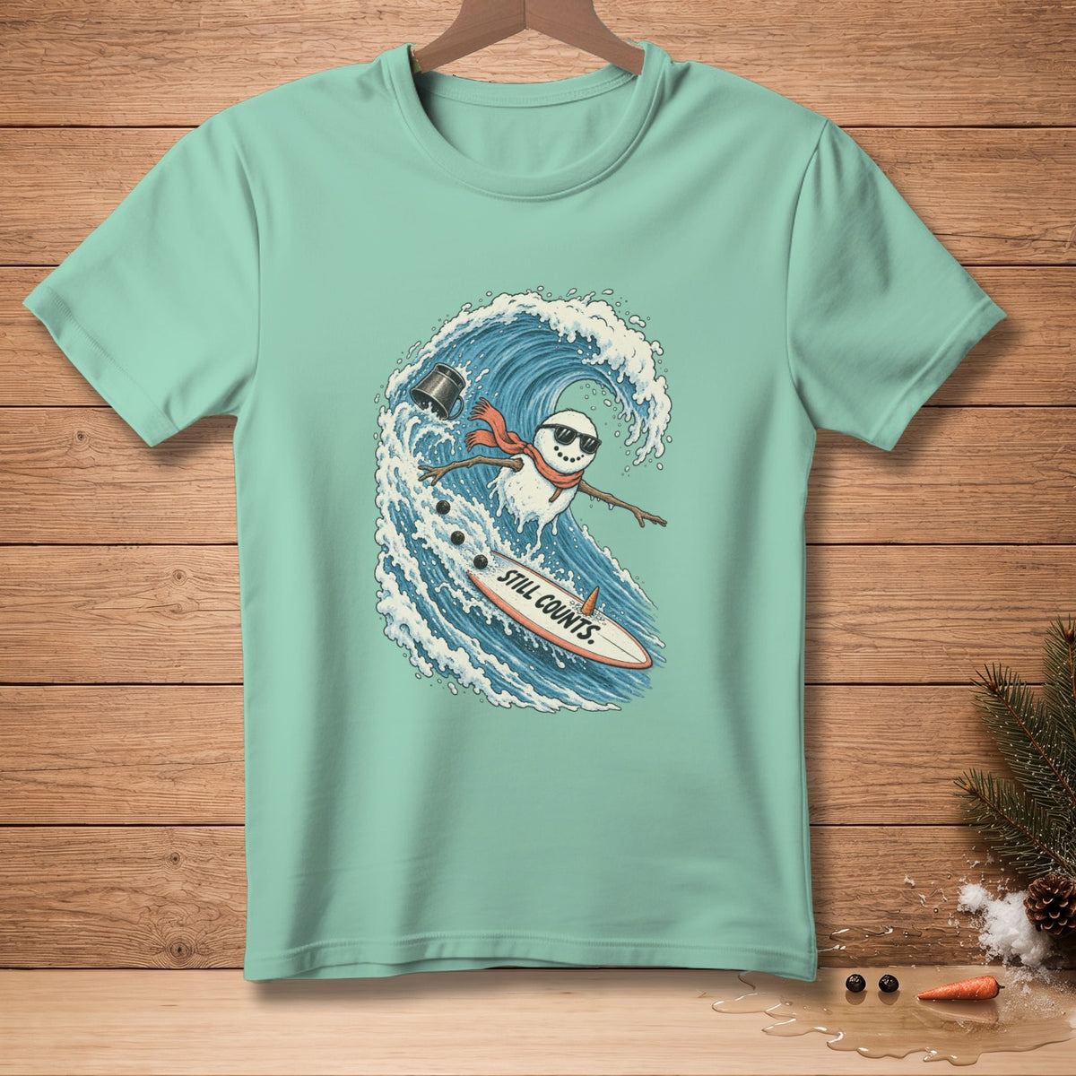 Snowman surfing a wave on a surfboard with text "STILL COUNTS."