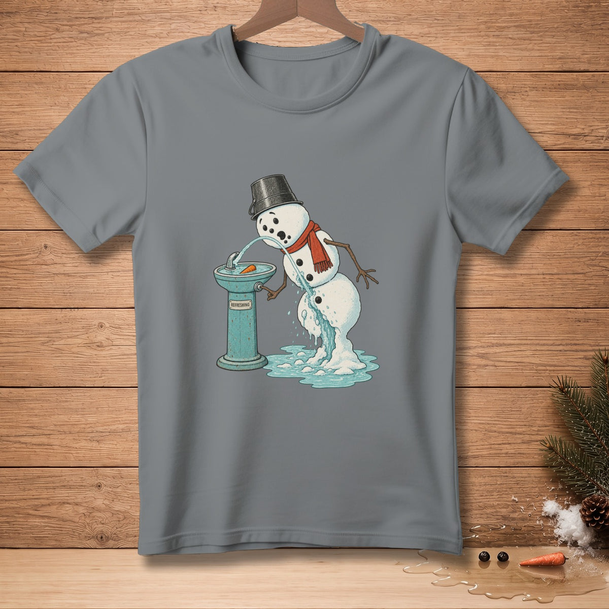 Melting snowman drinks from a fountain labeled "Refreshing" on a grey t-shirt.