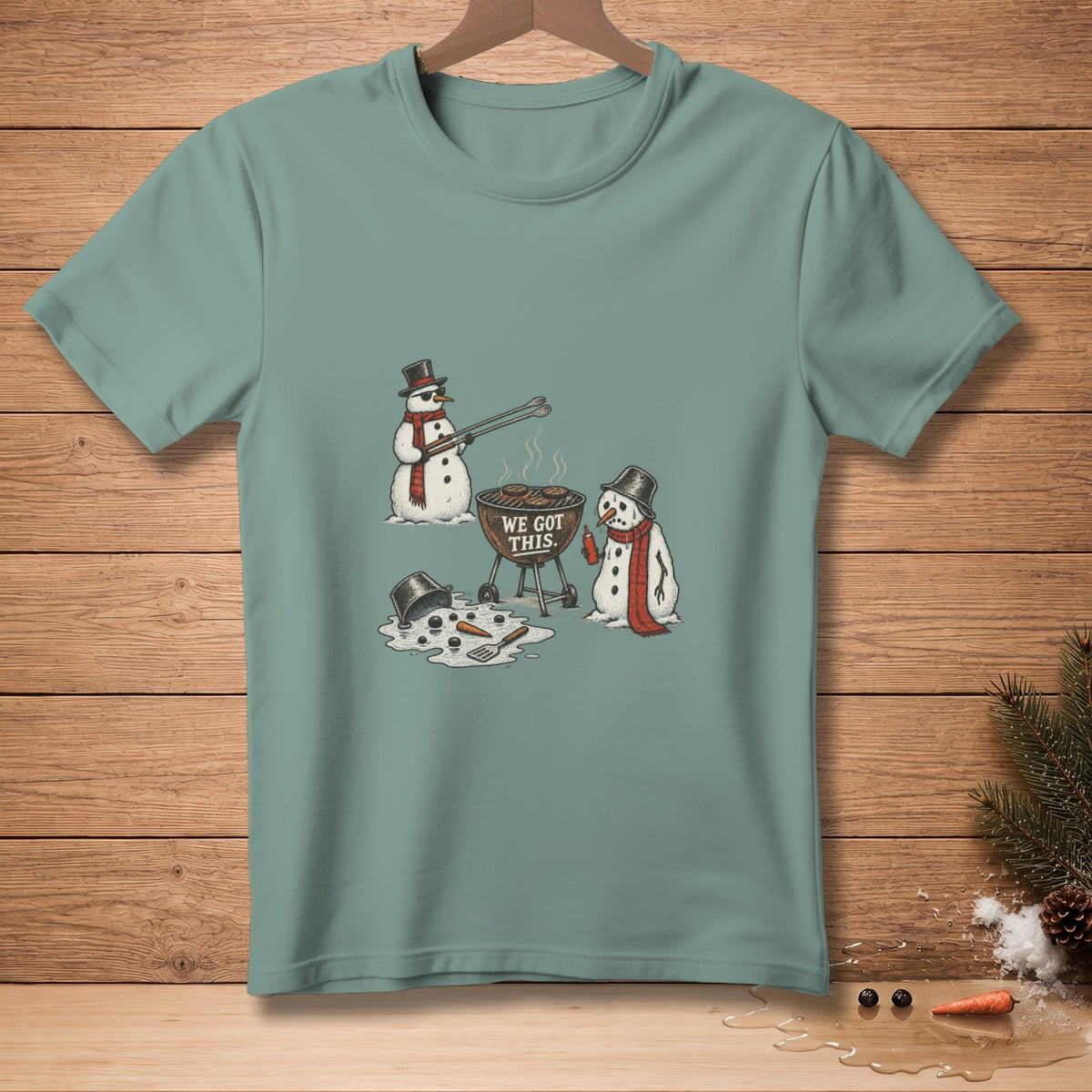 Two snowmen grilling with text "WE GOT THIS" on a green t-shirt.