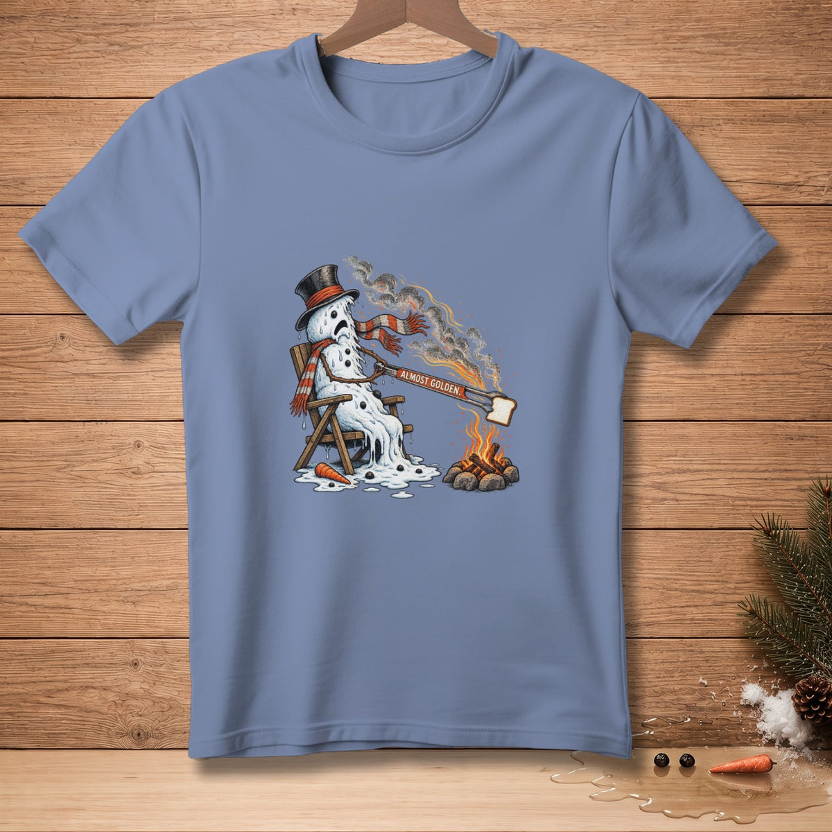 Melting snowman in lounge chair with toast over campfire, text "ALMOST GOLDEN."