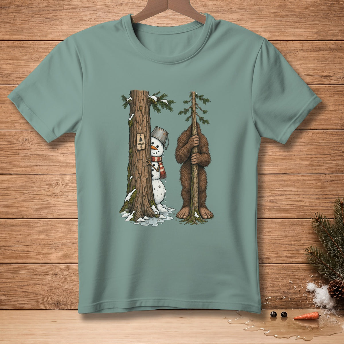 Snowman peeking from tree next to Bigfoot holding a sapling, "Nailed It." text.