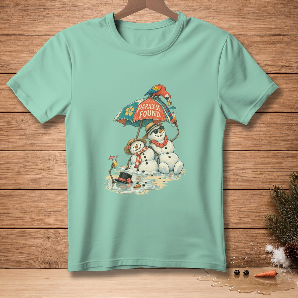 Two melting snowmen sit on a beach under an umbrella with "Paradise Found" on it.
