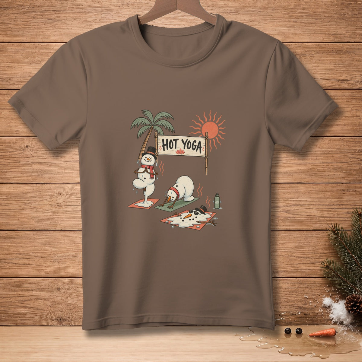 Snowmen doing yoga with a "Hot Yoga" sign on a brown t-shirt.