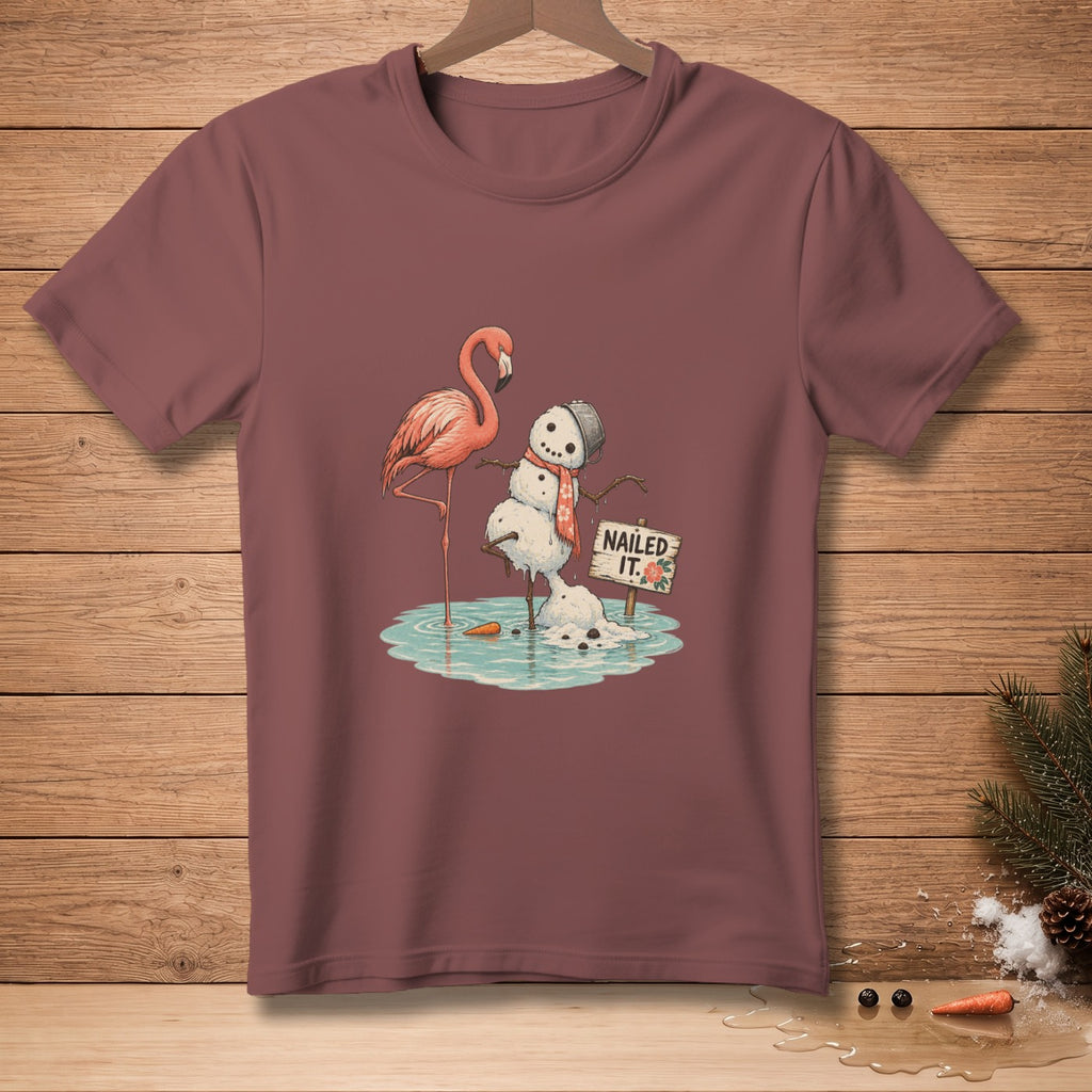 Flamingo balances on one leg beside a melting snowman with a "Nailed It" sign.