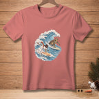 Salmon pink t-shirt featuring a cartoon snowman and turtle surfing on a wave.