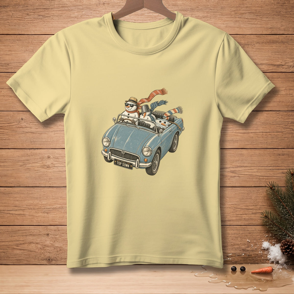 Snowmen in a blue convertible with a "Top Down" license plate on a light yellow t-shirt.