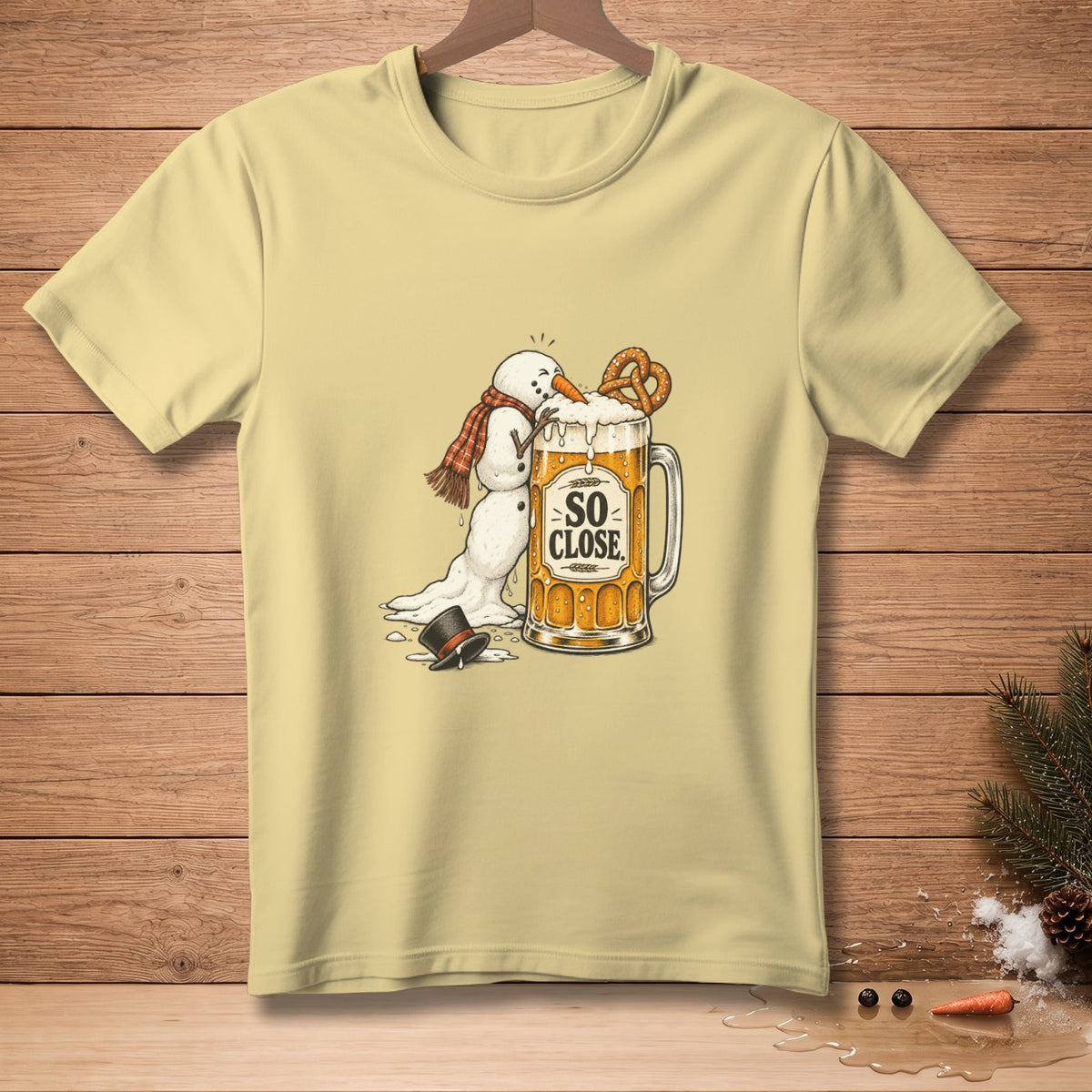 Yellow t-shirt with melting snowman reaching for a beer mug, text "So Close".