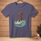 Bigfoot surfs with a melting snowman wearing a hat on a paddleboard.