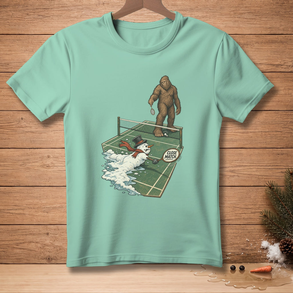 Bigfoot plays badminton against melting snowman with "Close Match" sign.