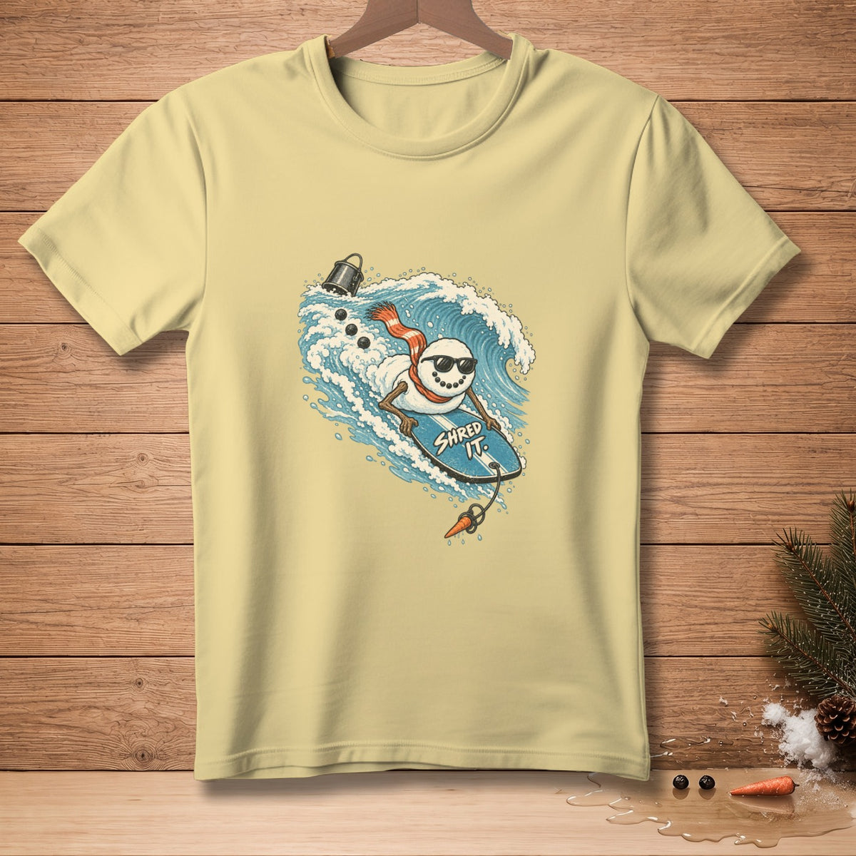 Snowman wearing sunglasses surfing a wave on a surfboard with "Shred It" text.