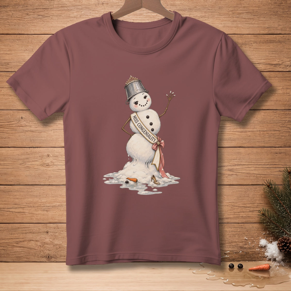 T-shirt with a melting snowman wearing a tiara and sash that reads "MISS CONGENIALITY".