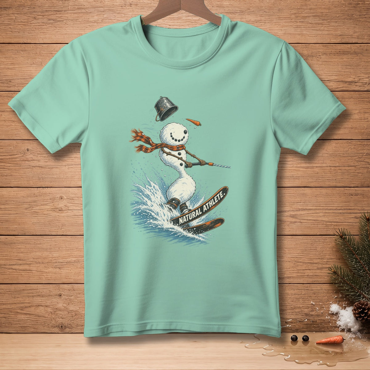 Light blue t-shirt with a graphic of a snowman skiing on skis with text "NATURAL ATHLETE."