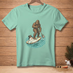 Bigfoot paddles a surfboard with a melting snowman, wearing a top hat.