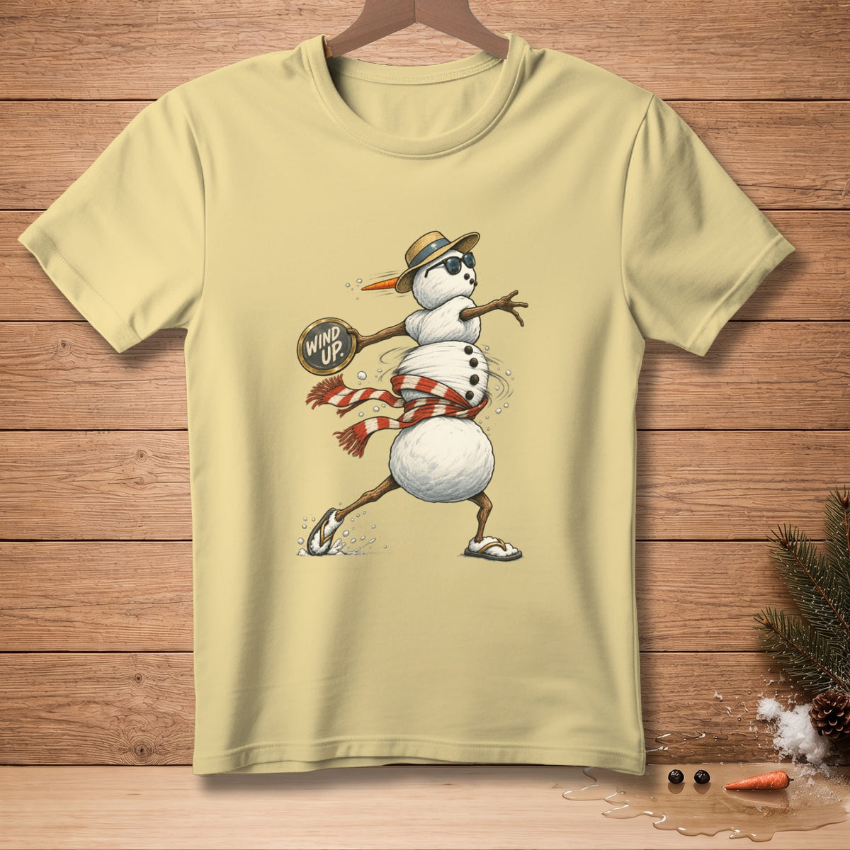 Yellow t-shirt with a cartoon snowman wearing a hat and sunglasses, playing tennis.