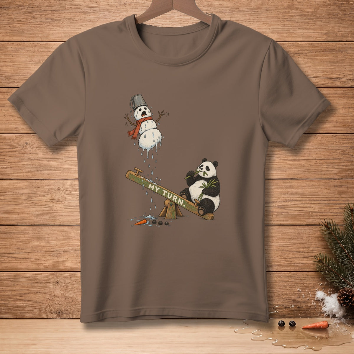 Brown t-shirt with a melting snowman and a panda on a seesaw saying "MY TURN."
