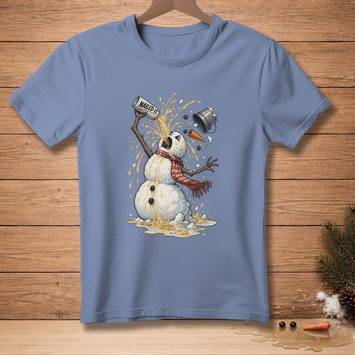 Snowman with a can labeled "NAILED IT!" spilling liquid on a blue t-shirt.