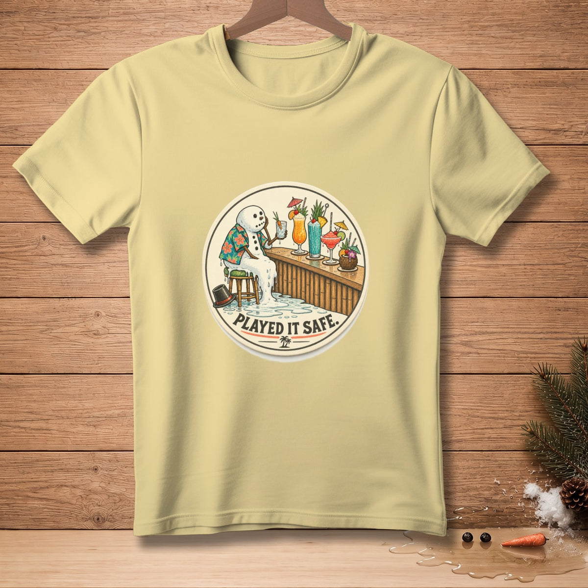 Light yellow t-shirt with a melting snowman at a bar, saying "Played it Safe".