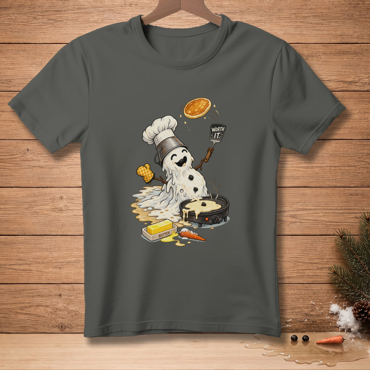 Melting snowman chef flipping pancake with "Worth It." spatula, cooking butter, and carrot.