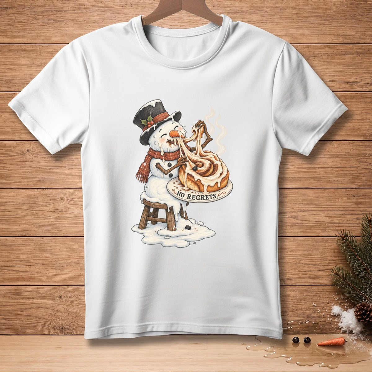 Snowman eating a cinnamon roll with "NO REGRETS" text on a white t-shirt.