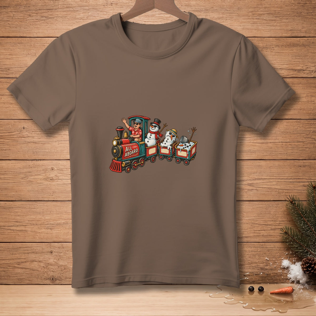 T-shirt graphic with a train featuring a person and snowmen. Text reads "ALL ABOARD."