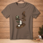 T-shirt graphic: Bigfoot walking past a melting snowman in mud.