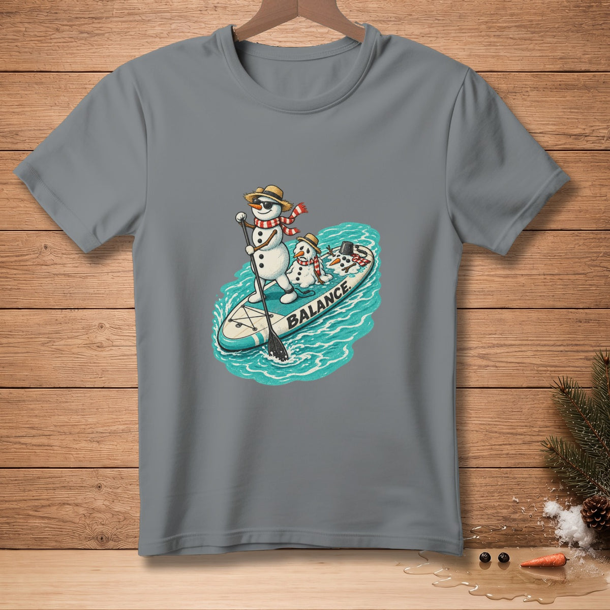 Snowmen paddleboarding on a surfboard with the word "BALANCE" on it.